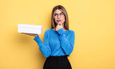 Düşünen, kuşkucu ve kafası karışık güzel bir kadın. Beyaz kutu tutuluyor