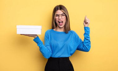 Güzel bir kadın sinirli bir ifadeyle agresif bir şekilde bağırıyor. Beyaz kutu tutuluyor