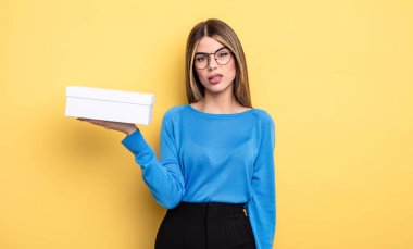 Güzel kadın şaşkın ve şaşkın hissediyor. Beyaz kutu tutuluyor