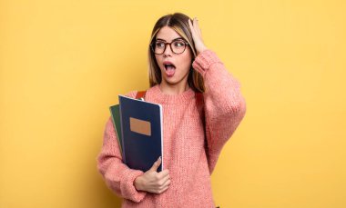 Güzel bayan öğrenci mutlu, heyecanlı ve şaşırmış hissediyor. kitaplar ve sırt çantası