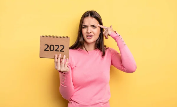 Pretty Woman Feeling Confused Puzzled Showing You Insane 2022 Calendar — Stockfoto