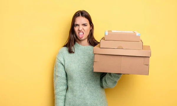 かなり女性はうんざりしていらいらして舌を出すパッケージボックスの概念 — ストック写真