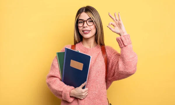 Ładna Studentka Czuje Się Szczęśliwa Okazując Aprobatę Dobrym Gestem Książki — Zdjęcie stockowe