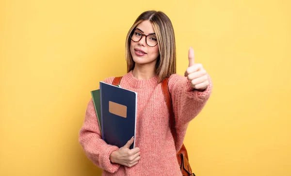 Ładna Studentka Czuje Się Dumna Uśmiecha Się Pozytywnie Podniesionymi Kciukami — Zdjęcie stockowe