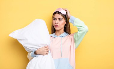 Güzel kadın şaşkın ve kafası karışık, kaşınan bir kafa hissediyor. pijama konsepti