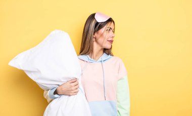 pretty woman on profile view thinking, imagining or daydreaming. pajamas concept
