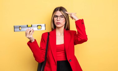 Mimar kadın şaşkın ve şaşkın hissediyor, deli olduğunu ve dengeyi elinde tuttuğunu gösteriyor.