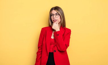 İş kadını mutlu ve kendinden emin bir ifadeyle gülümsüyor, elleri çenesinde.