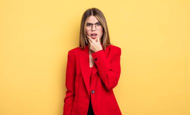 Ağzı ve gözleri açık ve eli çenesinde olan bir iş kadını.