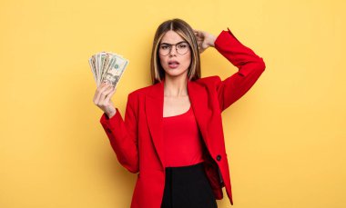 İş kadını kendini stresli, endişeli ya da korkmuş hissediyor. Elleri başının üstünde. Dolar banknotları konsepti