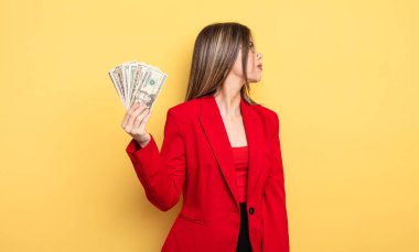 İş kadını profil görünümünde düşünüyor, hayal ediyor ya da hayal kuruyor. Dolar banknotları konsepti