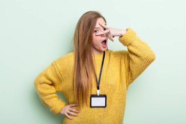 Kızıl saçlı, şok olmuş, korkmuş ya da dehşete düşmüş, yüzü elle kapatılmış gibi görünüyor. akreditasyon kartı kavramı