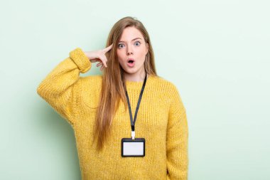 Kızıl saçlı şaşırmış görünüyor, yeni bir düşünce, fikir ya da konseptin farkına varıyor. akreditasyon kartı kavramı