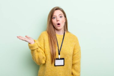 Kızıl saçlı şaşırmış ve şok olmuş görünüyordu. Çenesi düşmüş ve elinde bir nesne tutuyordu. akreditasyon kartı kavramı