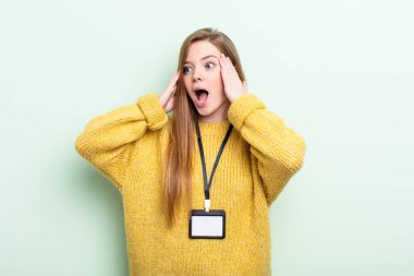 Kızıl saçlı mutlu, heyecanlı ve şaşırmış hissediyor. akreditasyon kartı kavramı