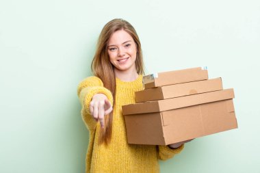 Kızıl saçlı kadın kamerayı göstererek seni seçiyor. paket kutuları konsepti