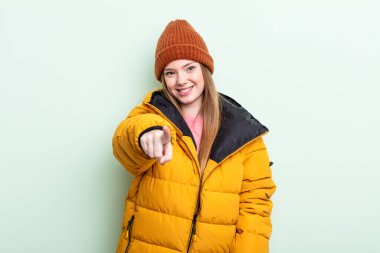 Kızıl saçlı kadın seni seçen kamerayı işaret ediyor. kış konsepti