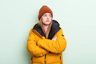 Kızıl saçlı kadın omuz silkiyor, kafası karışık ve kararsız. kış konsepti