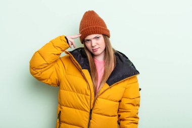 Kızıl saçlı kadın şaşkın ve şaşkın hissediyor, senin deli olduğunu gösteriyor. kış konsepti