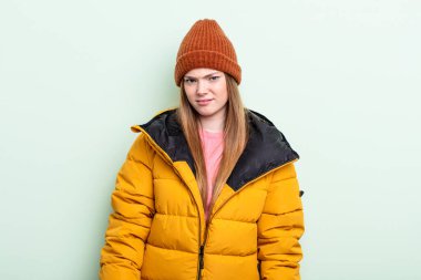 Kızıl saçlı kadın üzgün, üzgün ya da kızgın ve yana bakıyor. kış konsepti