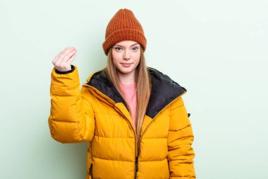 Kızıl saçlı kadın kapiş ya da para hareketi yapıyor, sana ödemeni söylüyor. kış konsepti