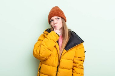 Kızıl saçlı kadın düşünüyor, kuşkulu ve şaşkın hissediyor. kış konsepti