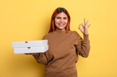 İspanyol kadın kendini mutlu hissediyor, iyi bir jestle onaylıyor. Pizza konseptini kaldır.