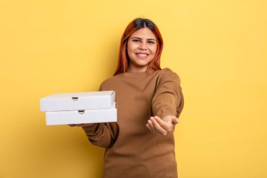 İspanyol kadın mutlu bir şekilde gülümsüyor ve bir konsept sunuyor. Pizza konseptini kaldır.