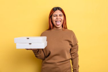 Neşeli ve asi tavırlı İspanyol kadın, şaka yapıyor ve dil çıkarıyor. Pizza konseptini kaldır.