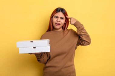 İspanyol kadın şaşkın ve şaşkın hissediyor, senin deli olduğunu gösteriyor. Pizza konseptini kaldır.