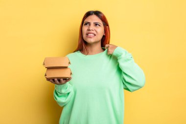 İspanyol kadın stresli, endişeli, yorgun ve hayal kırıklığına uğramış hissediyor. Hamburger konseptini kaldır.