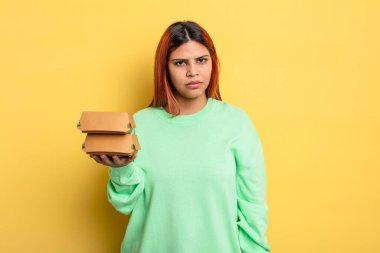 Hispanik kadın üzgün, üzgün ya da kızgın ve yana bakıyor. Hamburger konseptini kaldır.