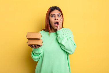 İspanyol kadın şok olmuş ve korkmuş hissediyor. Hamburger konseptini kaldır.