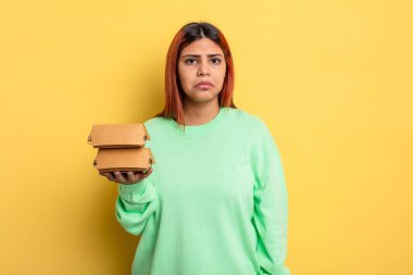 İspanyol kadın üzgün ve mızmızlanıyor. Mutsuz bir bakışı var ve ağlıyor. Hamburger konseptini kaldır.