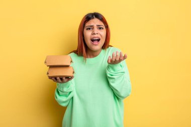 İspanyol kadın umutsuz, sinirli ve stresli görünüyor. Hamburger konseptini kaldır.