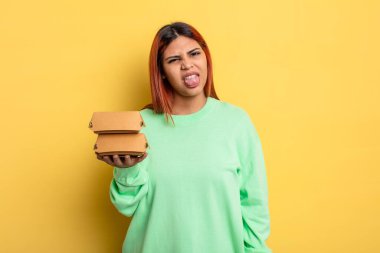 İspanyol kadın iğreniyor, sinirleniyor ve dilini çıkarıyor. Hamburger konseptini kaldır.