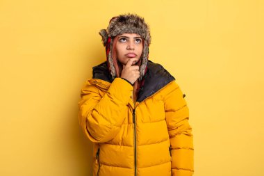 Hispanik kadın düşünüyor, kuşkulu ve şaşkın hissediyor. kış konsepti