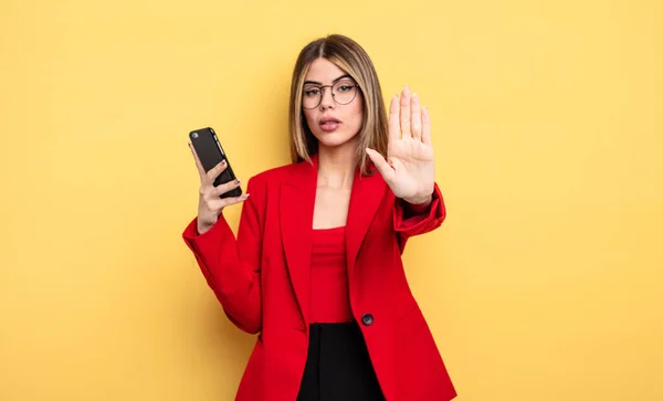 Affärskvinna Ser Allvarligt Visar Öppen Handflata Gör Stopp Gest Smartphone — Stockfoto