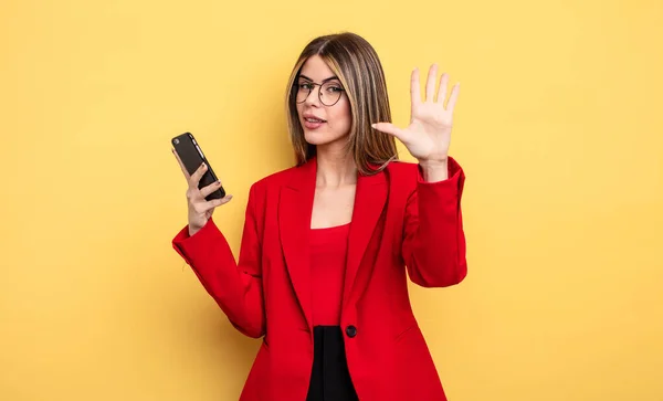 Affärskvinna Ler Och Ser Vänlig Visar Nummer Fem Smartphone Koncept — Stockfoto