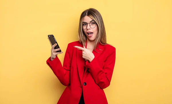 Affärskvinna Ser Upphetsad Och Förvånad Pekar Sidan Smartphone Koncept — Stockfoto