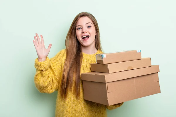 赤い髪の女性は何か信じられないほどの幸せと驚きを感じる パッケージボックスのコンセプト — ストック写真