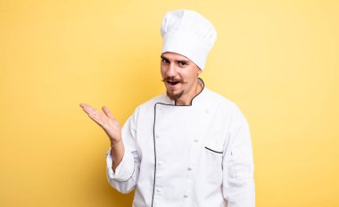 Şaşkın ve şaşkın bakan şef, çenesi düşmüş bir nesne tutuyor