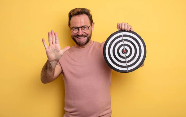 Middle Age Man Smiling Looking Friendly Showing Number Five Dart — Zdjęcie stockowe