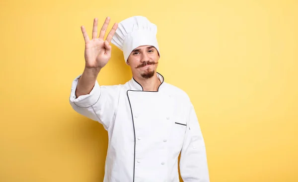 Küchenchef Lächelt Freundlich Und Zeigt Nummer Vier — Stockfoto