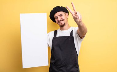 Gülümseyen ve mutlu görünen sanatçı zafer ya da barış işareti yapıyor. boşluk konseptini kopyala