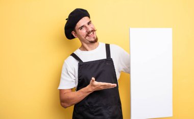 Ressam neşeli bir şekilde gülümser, mutlu hisseder ve bir konsept gösterir. boşluk konseptini kopyala