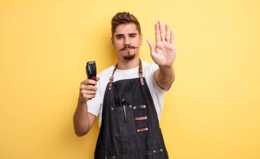 Hipster berber ciddi görünüyor. Avuç içini gösteriyor. Durdurma hareketi yapıyor.