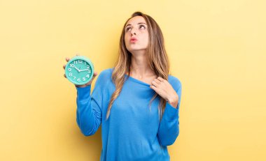 pretty woman feeling stressed, anxious, tired and frustrated holding an alarm clock