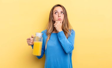 pretty woman thinking, feeling doubtful and confused orange juice concept