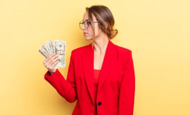 pretty woman on profile view thinking, imagining or daydreaming. business and dollar banknotes concept